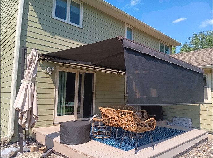 Installed retractable awning creating shade near a home